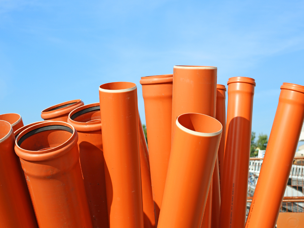 A stack of orange PVC drainage pipes﻿﻿