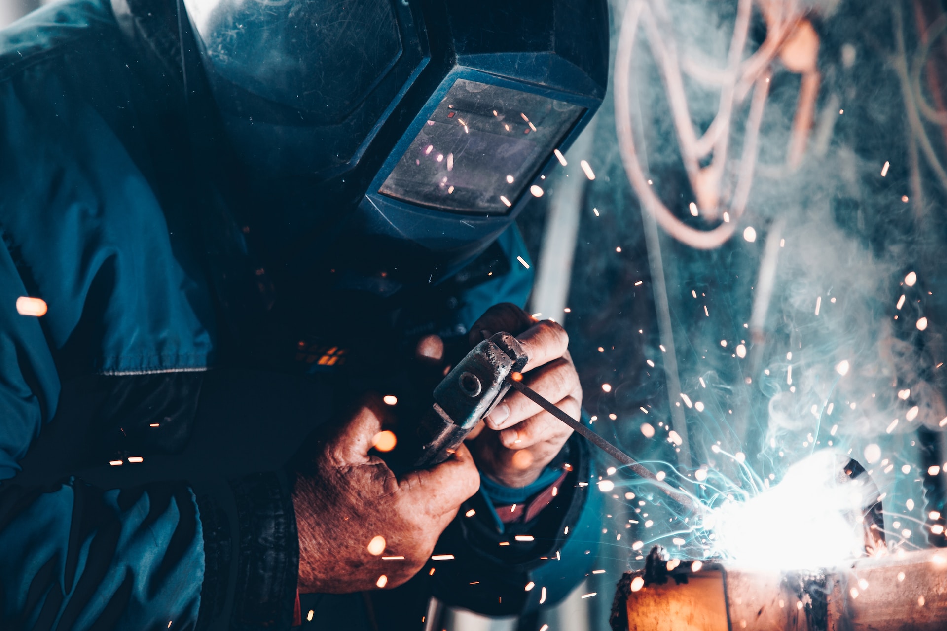 Welder in action welding square bar